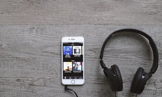 Bangkok, Thailand - April 28, 2018: Flat lay of headphone and smart phone with Spotify app on screen. Spotify is one of popular 