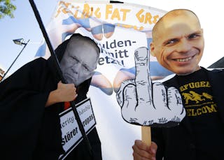 Demonstrators sporting the masks depicting German Finance Minister Schaeuble and former Greek Finance Minister Varoufakis take p