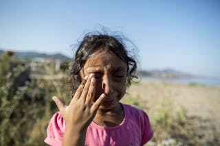 Yasmine, a 6-year-old migrant from Deir Al Zour in war-torn Syria, cries at the beach after arriving on the Greek island of Lesb