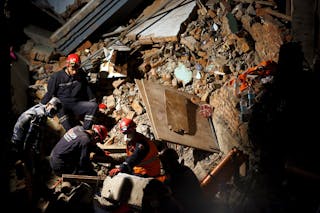 Rescue team member from Nepal, Turkey and china works during the rescue operation to rescue live victims trapped inside the coll