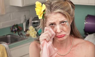 Caucasian housewife wipes tears with napkin in her kitchen