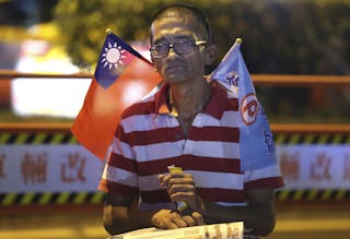 A man carrying a Taiwan national flag reacts after Nationalist Party (KMT) Taipei mayoral candidate Lien conceded defeat at the 