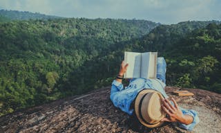 Asian man travel relax in the holiday. sleep relax read books on rocky cliffs. On the Moutain. In Thailand