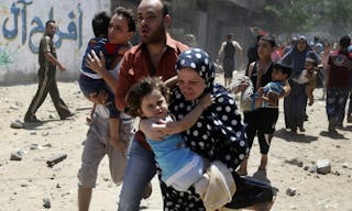 Palestinians run following what police said was an Israeli air strike on a house in Gaza