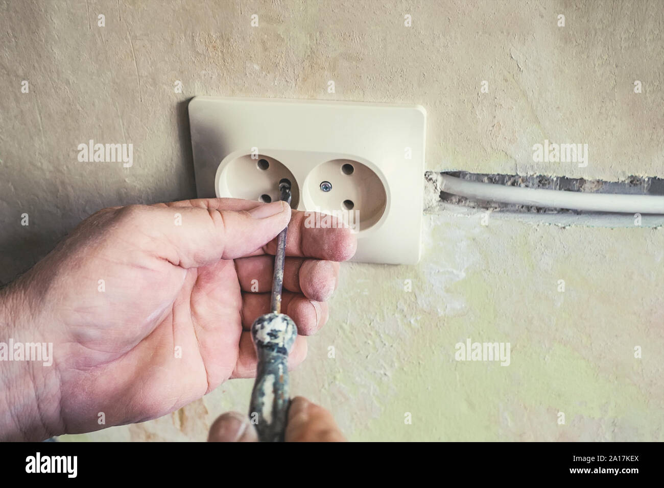 Repair of electrical outlets in the wall of the house.Old broken light switch with power connection in old broken factory. Selective focus Stock Photo