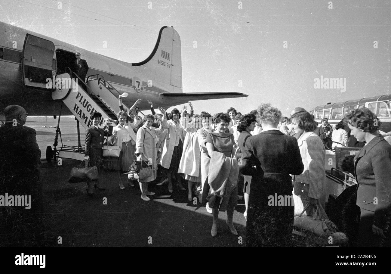 A group of young German women just before boarding a plane to Melbourne. They had decided to emigrate to Australia.  At that time the Australian government  attracted immigrants by offering them financial support and many young women and men accepted the offers. Stock Photo