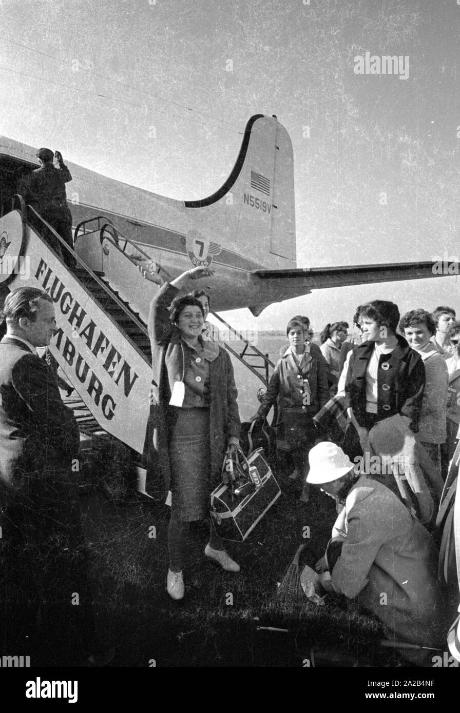 A group of young German women just before boarding a plane to Melbourne. They had decided to emigrate to Australia.  At that time the Australian government  attracted immigrants by offering them financial support and many young women and men accepted the offers. Stock Photo