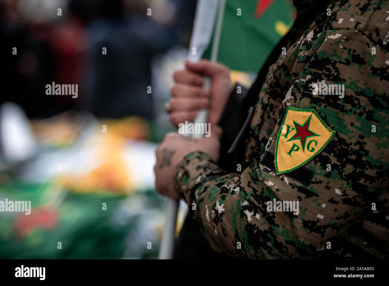 Cologne, Germany. 19th Oct, 2019. A demonstrator wears a jacket with the YPG logo during a demonstration against the Turkish military offensive in Northern Syria. Credit: Fabian Strauch/dpa/Alamy Live News Stock Photo