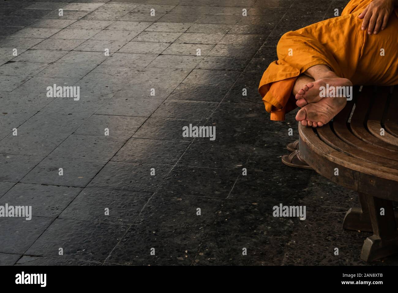 Bangkok, thailand - Jul 7, 2019 : A monk is sleep on wooden chairs are waiting for trains in the area provided at Main railway station of Hua Lamphong Stock Photo