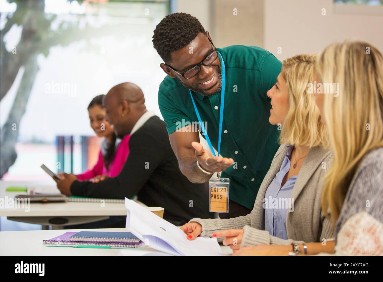 Community college instructor helping students in classroom Stock Photo