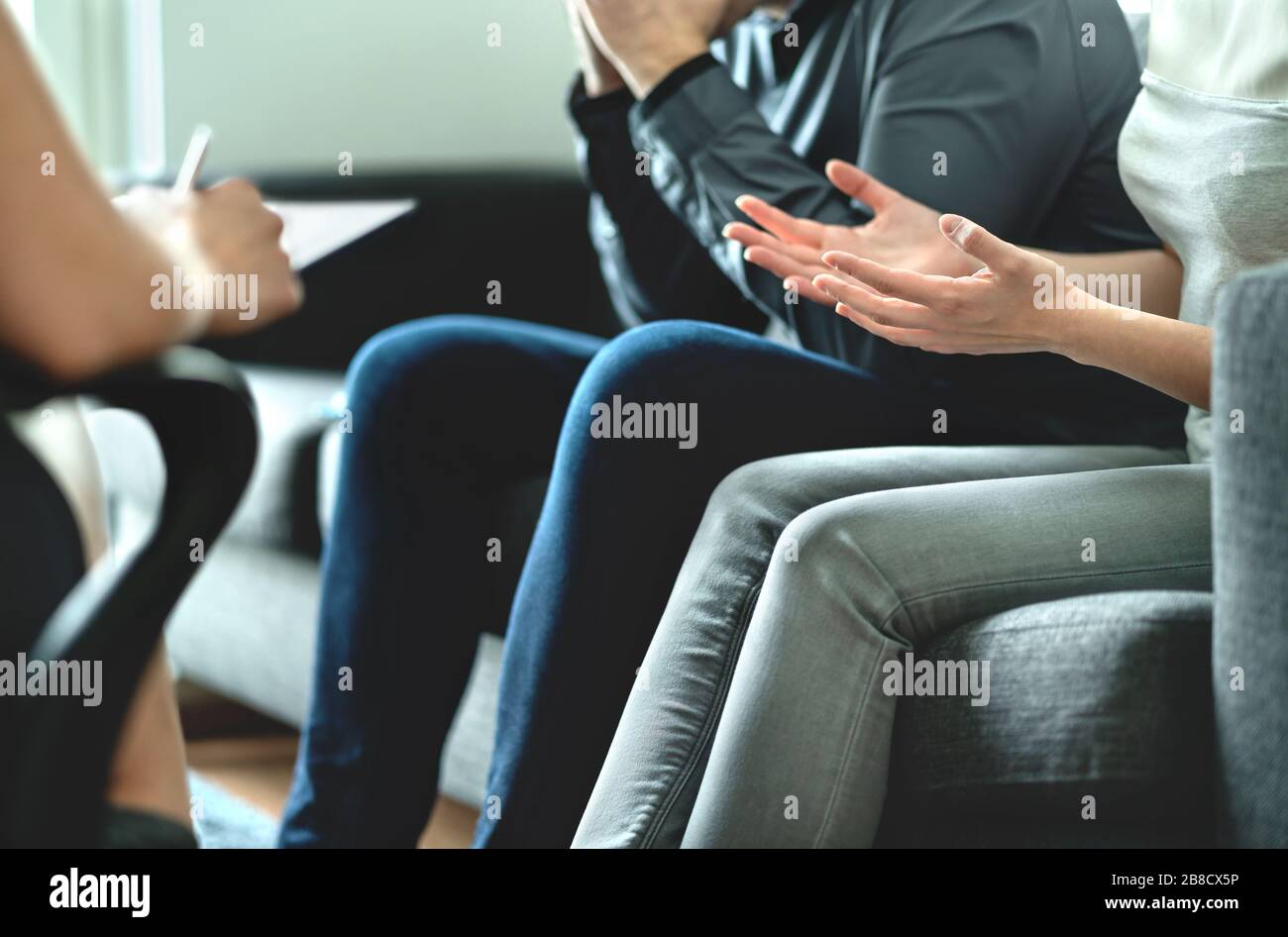 Angry couple argue in therapy. Dispute in marriage counseling. Custody battle, divorce, adoption, alimony, prenup or family problem. Stock Photo