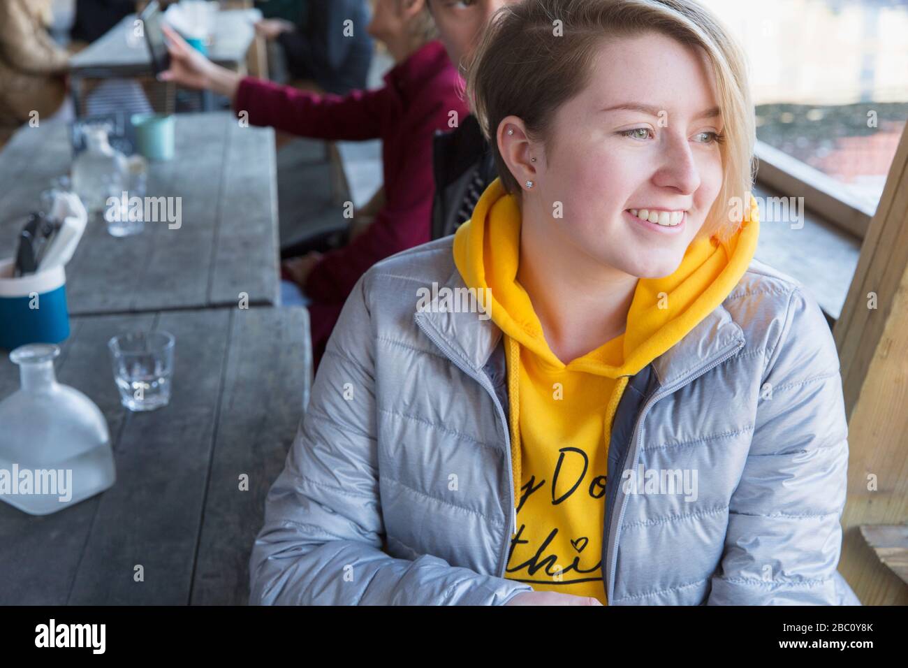 Smiling young woman dining at restaurant outdoor patio Stock Photo