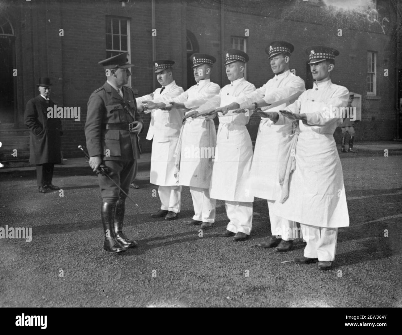 Teams , each consisting of a sergeant or superintending cook , and four men , competed in the 1934 Army Cookery competitions at the Army School of Cookery , Aldershot . Photo shows , cooks of the 1st Battalion Scots Guards having their hands inspected before going into action in the contest . 13 March 1934 Stock Photo