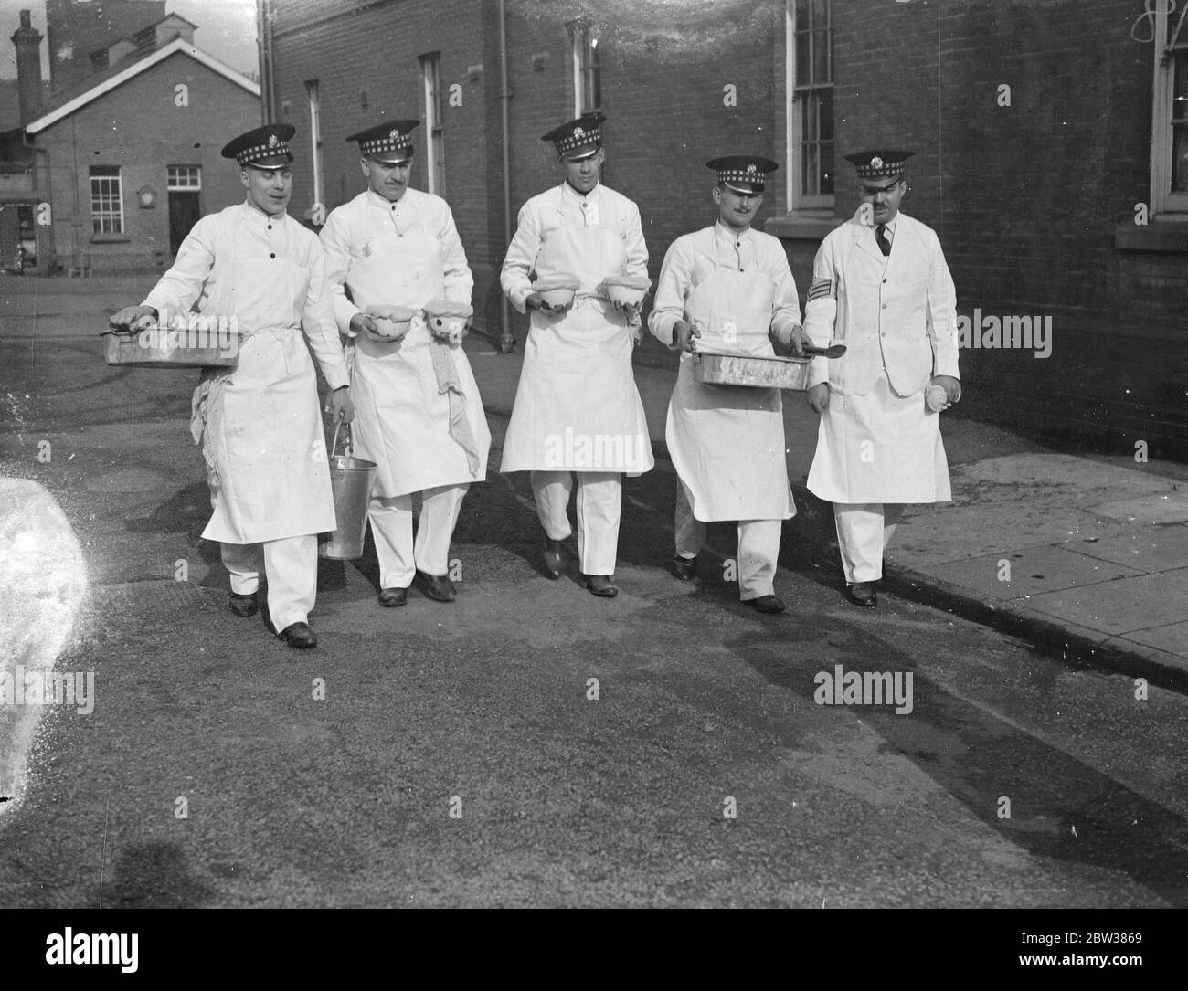 Teams , each consisting of a sergeant or superintending cook , and four men , competed in the 1934 Army Cookery competitions at the Army School of Cookery , Aldershot . Photo shows , cooks of the 1st Battalion Scots Guards having their hands inspected before going into action in the contest . 13 March 1934 Stock Photo