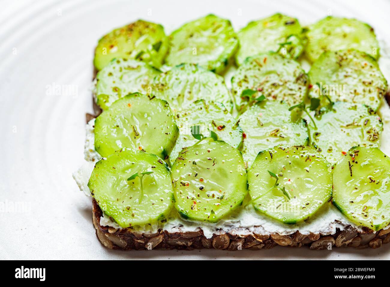 Cucumber and cream cheese toast on a plate. Healthy vegetarian diet concept. Stock Photo