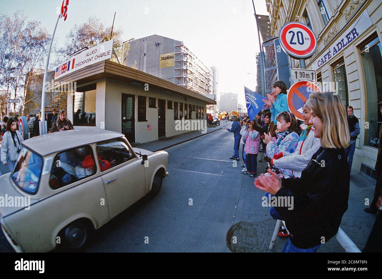 West German children applaud as East German visitors drive through Checkpoint Charlie and take advantage of relaxed travel restrictions to visit the West. Stock Photo