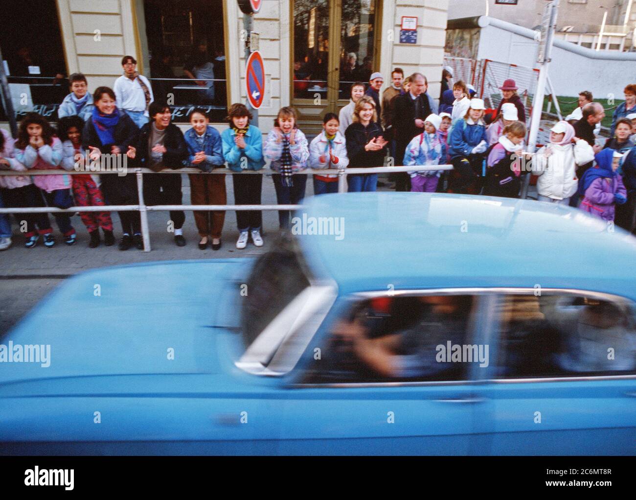 West German children applaud as an East German visitors drive through Checkpoint Charlie and take advantage of relaxed travel restrictions to visit West. Stock Photo