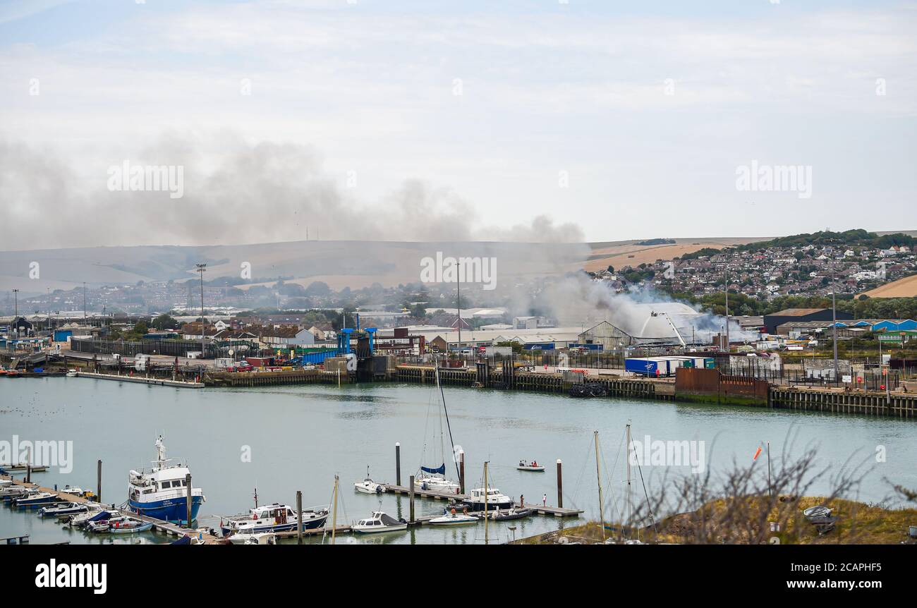 Newhaven UK 8th August 2020 - Smoke rises above Newhaven Port in East Sussex as firefighters battle a blaze near the railway station : Credit Simon Dack / Alamy Live News Stock Photo