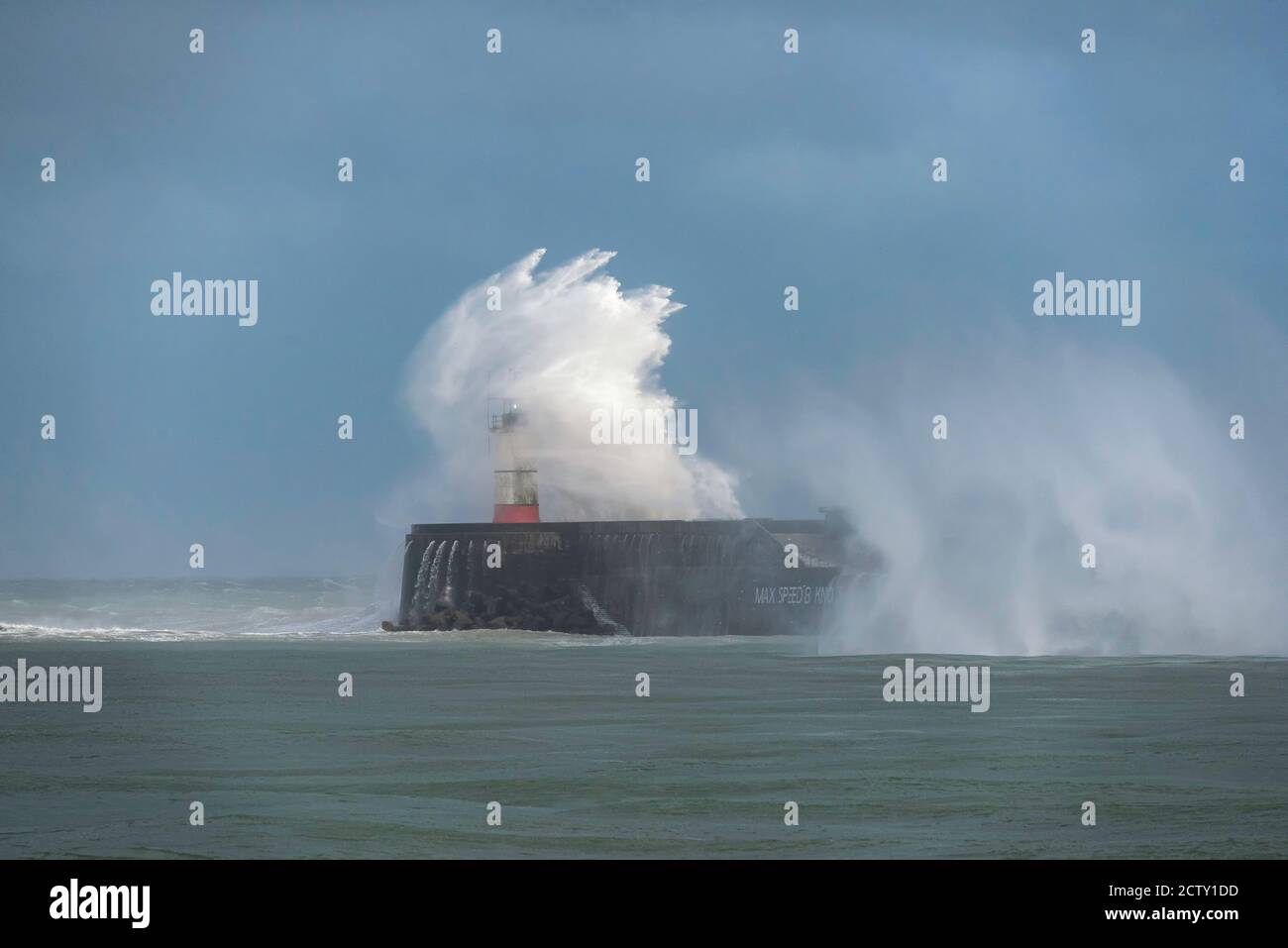 Storm waves breaking over the harbour arm and lighthouse at Newhaven, East Sussex, UK Stock Photo