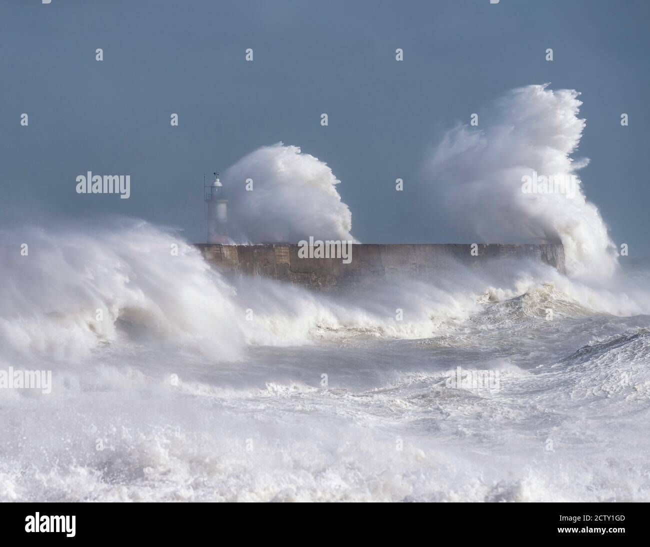 Storm waves breaking over the harbour arm and lighthouse at Newhaven, East Sussex, UK Stock Photo