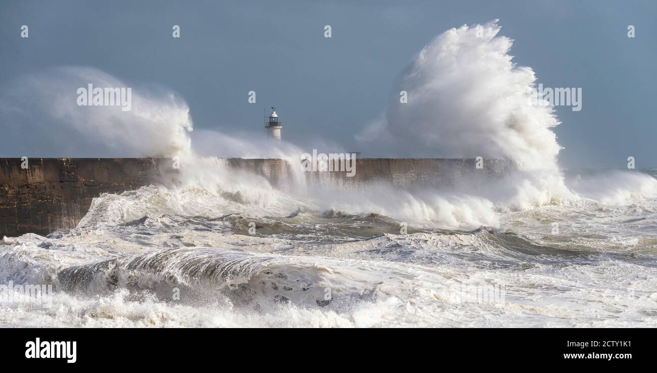 Storm waves breaking over the harbour arm and lighthouse at Newhaven, East Sussex, UK Stock Photo