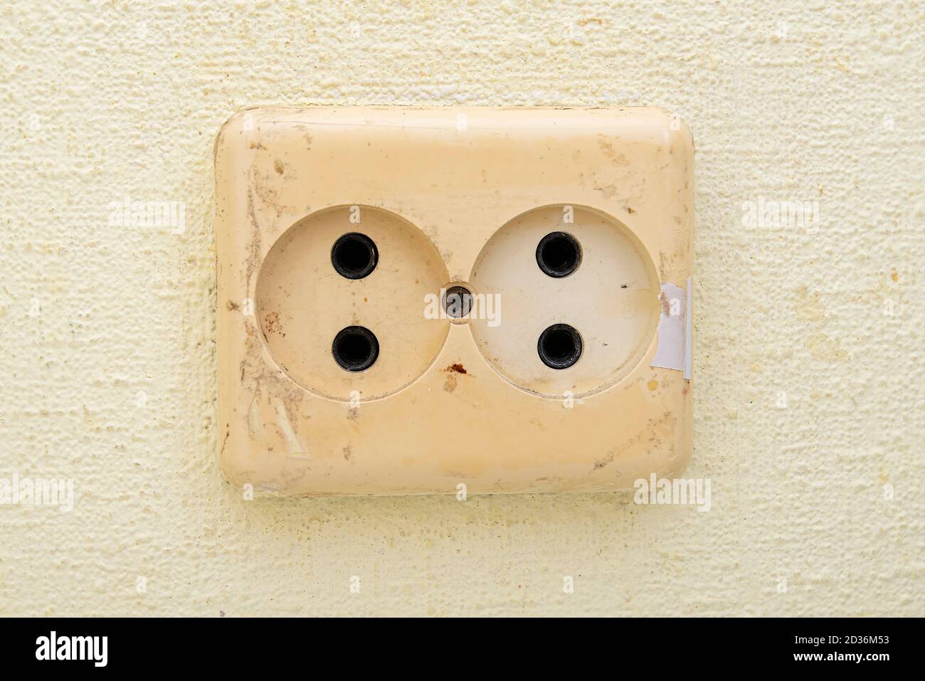 Dirty used electric power socket on old wall, room, interior Stock Photo