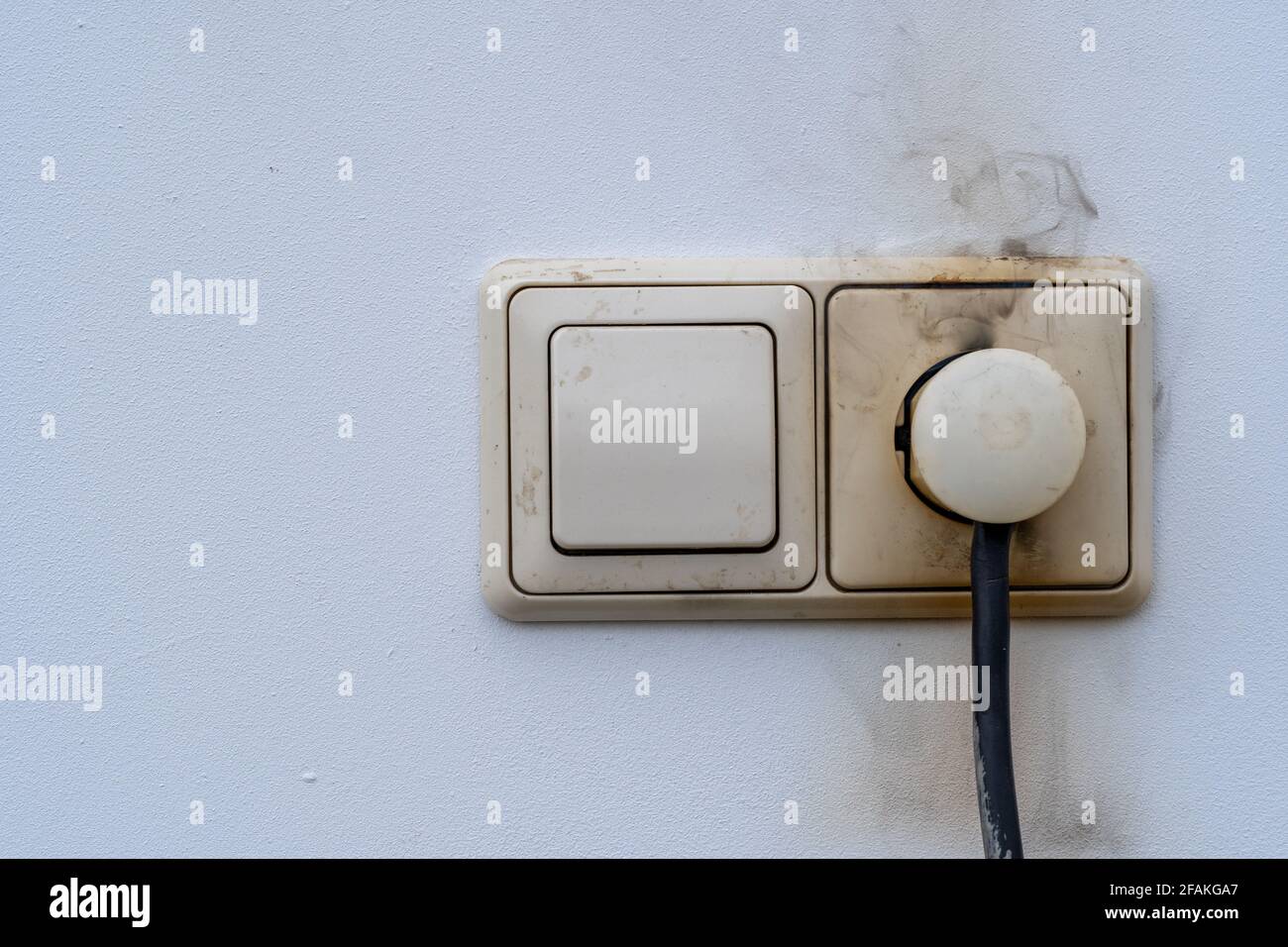 Close-up of electrical fire with the wire and wall plug Stock Photo