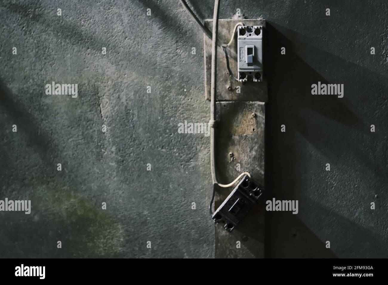 Old electrical outlet on gray concrete wall Stock Photo