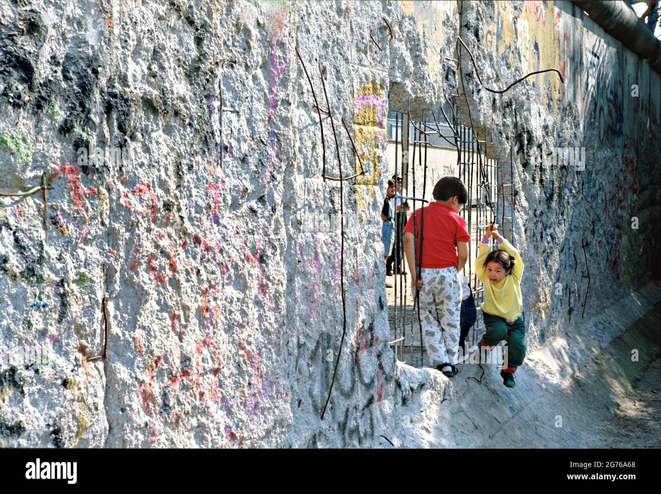 Berlin, Germany. 20 April 1990. Children play at a section of the Berlin Wall chipped away by souvenir hunters April 20, 1990 in West Berlin, West Germany. The wall separating East and West Germany came down November 9, 1989. Stock Photo