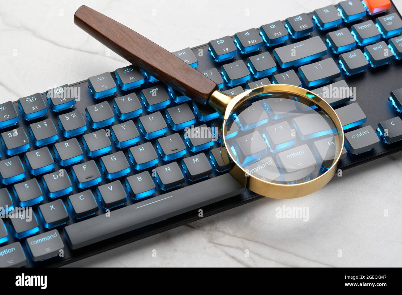 Magnifying glass on a computer keyboard. Illustrating a search of the internet. Finding things by use of a computer. Stock Photo