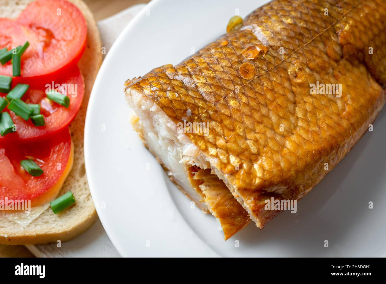 Smoked whitefish on a plate with tomato sandwich Stock Photo