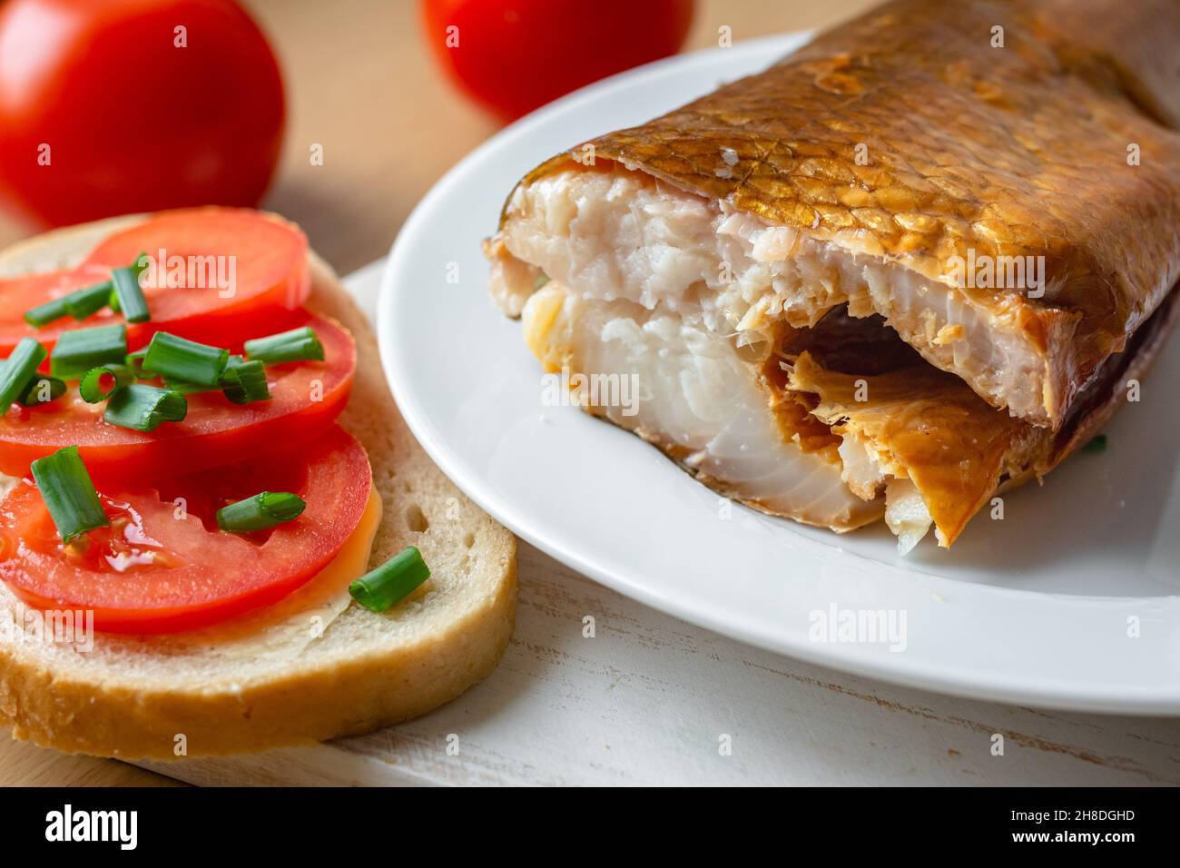 Smoked whitefish on a plate with tomato sandwich Stock Photo