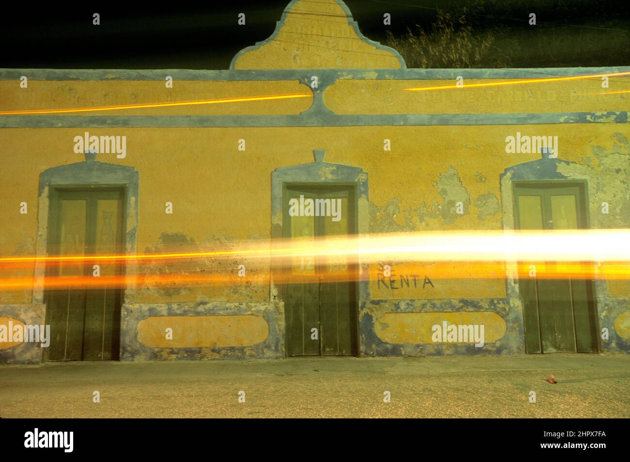 Three Mexican doors photographed at night with a vehicle driving past in downtown Celustun, Yucatan Peninsula, Mexico Stock Photo