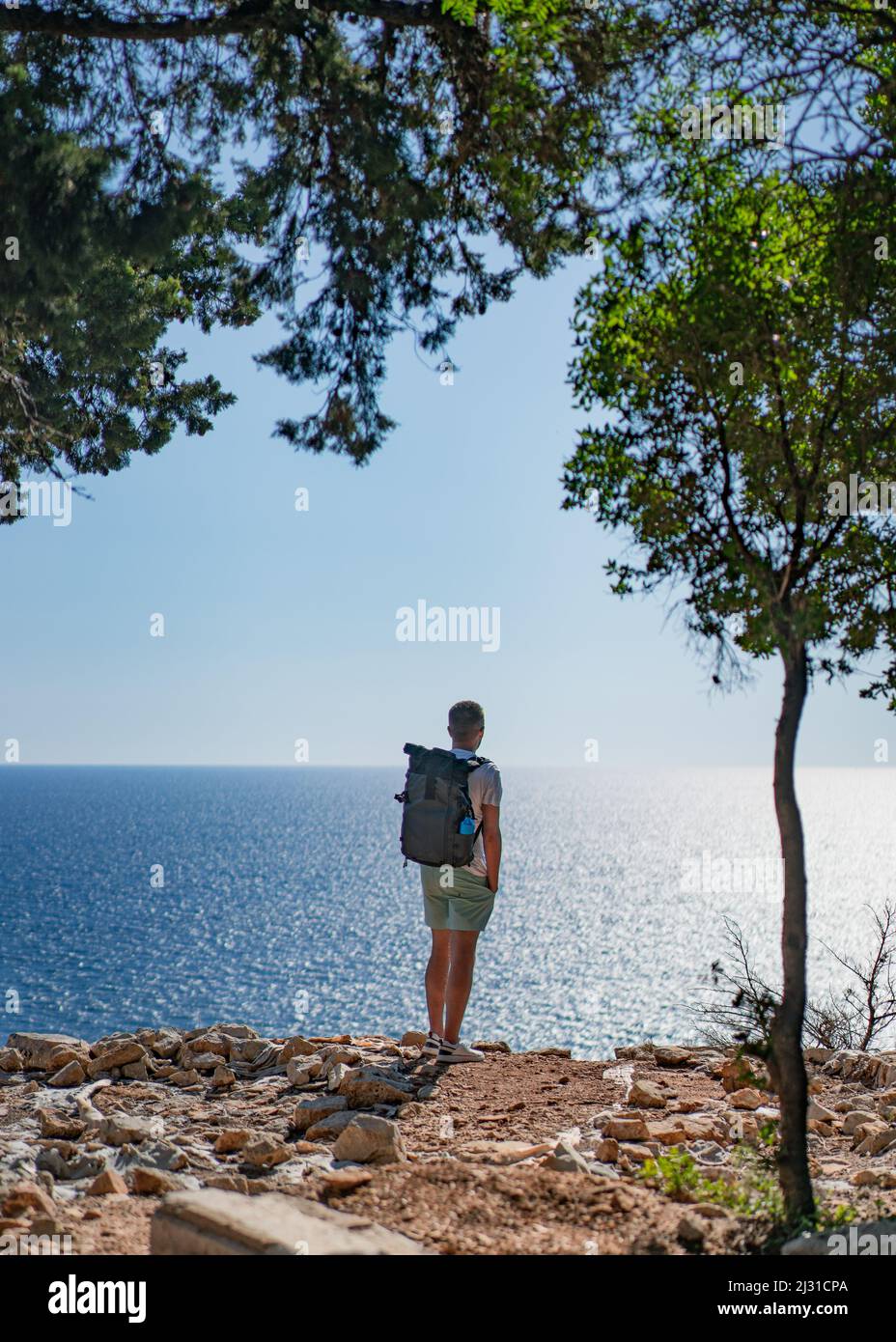 Man looks out from the island of Lokrum out to the Adriatic Sea in front of Dubrovnik, Dalmatia, Croatia. Stock Photo