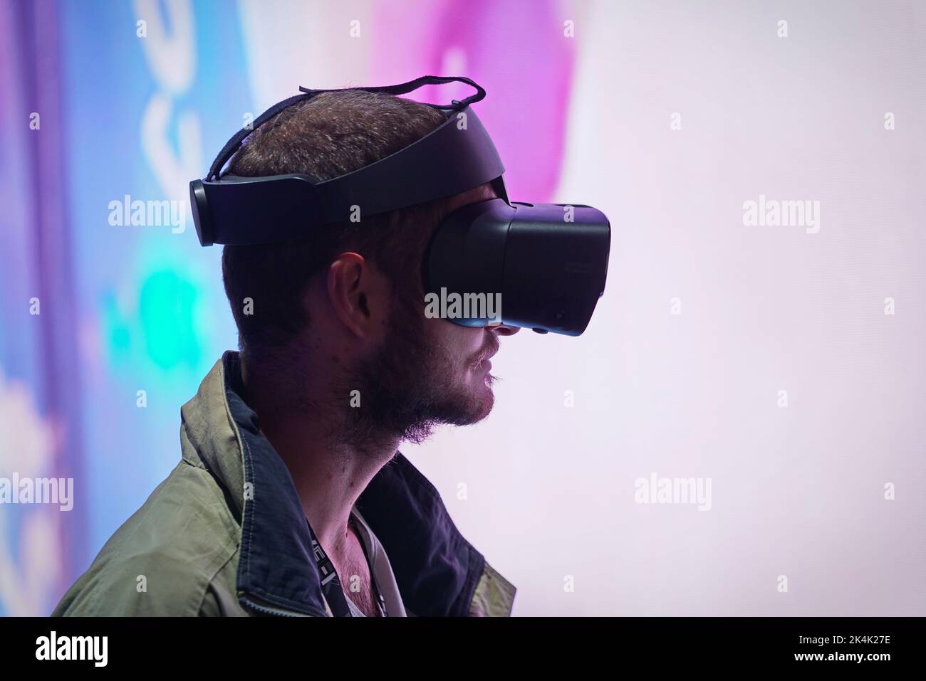 Virtual reality exhibit. Young man wears virtual reality goggles experiences a metaverse encounter. Turin, Italy - September 2022 Stock Photo