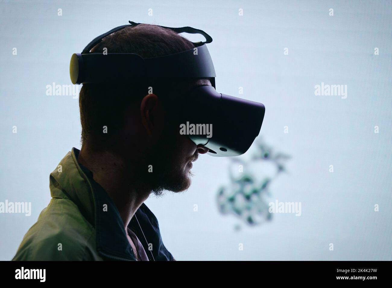 Virtual reality exhibit. Young man wears virtual reality goggles experiences a metaverse encounter. Turin, Italy - September 2022 Stock Photo