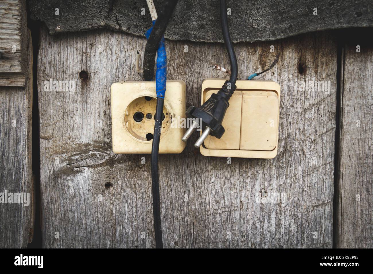 Old socket. Switch and socket. Broken electrical appliances. Dangerous wires. Stock Photo