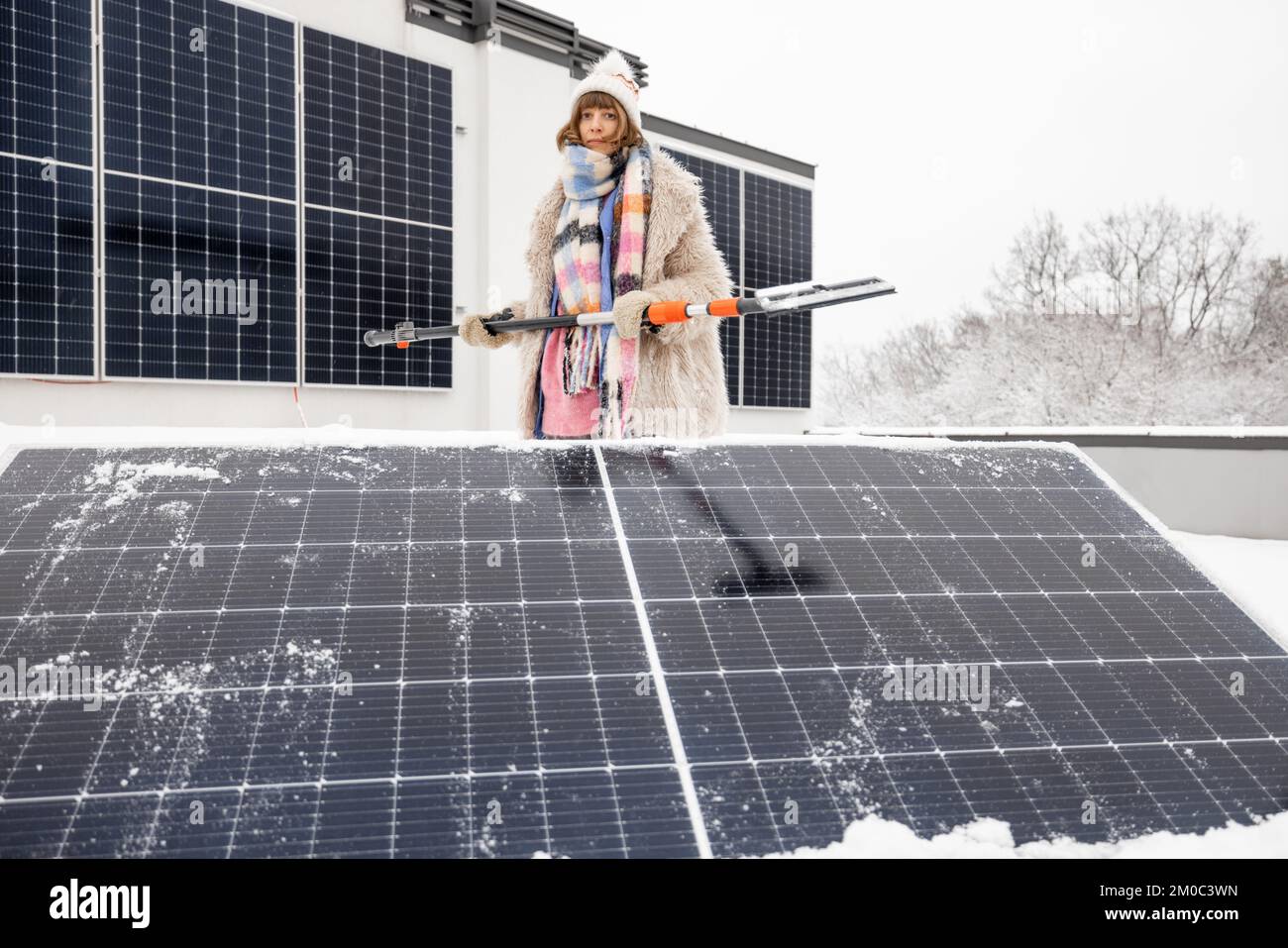 Woman cleans solar panels from snow Stock Photo