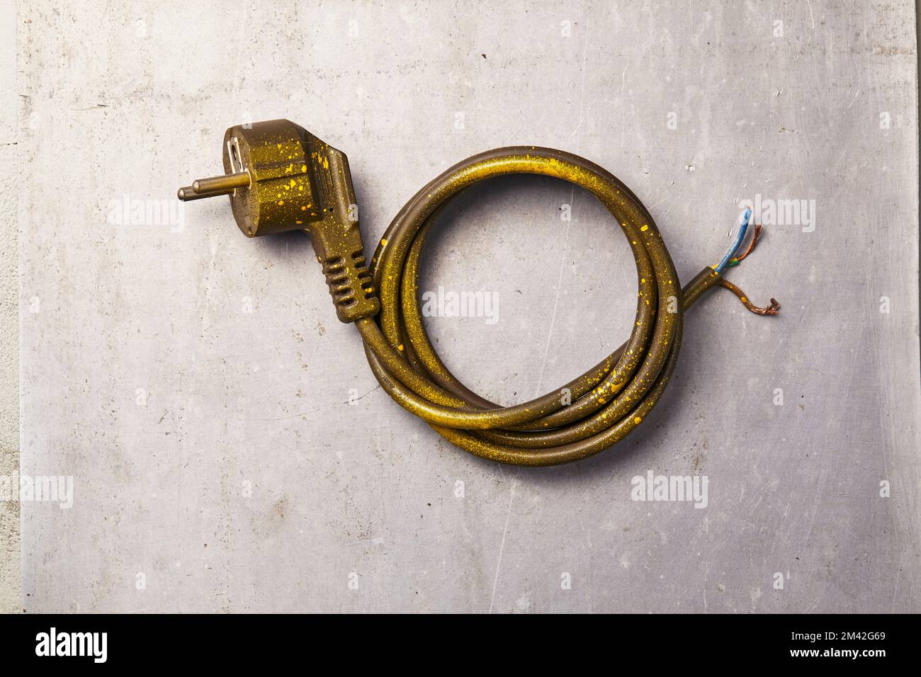 a used and broken power outlet with its wires neatly coiled lying on the floor Stock Photo