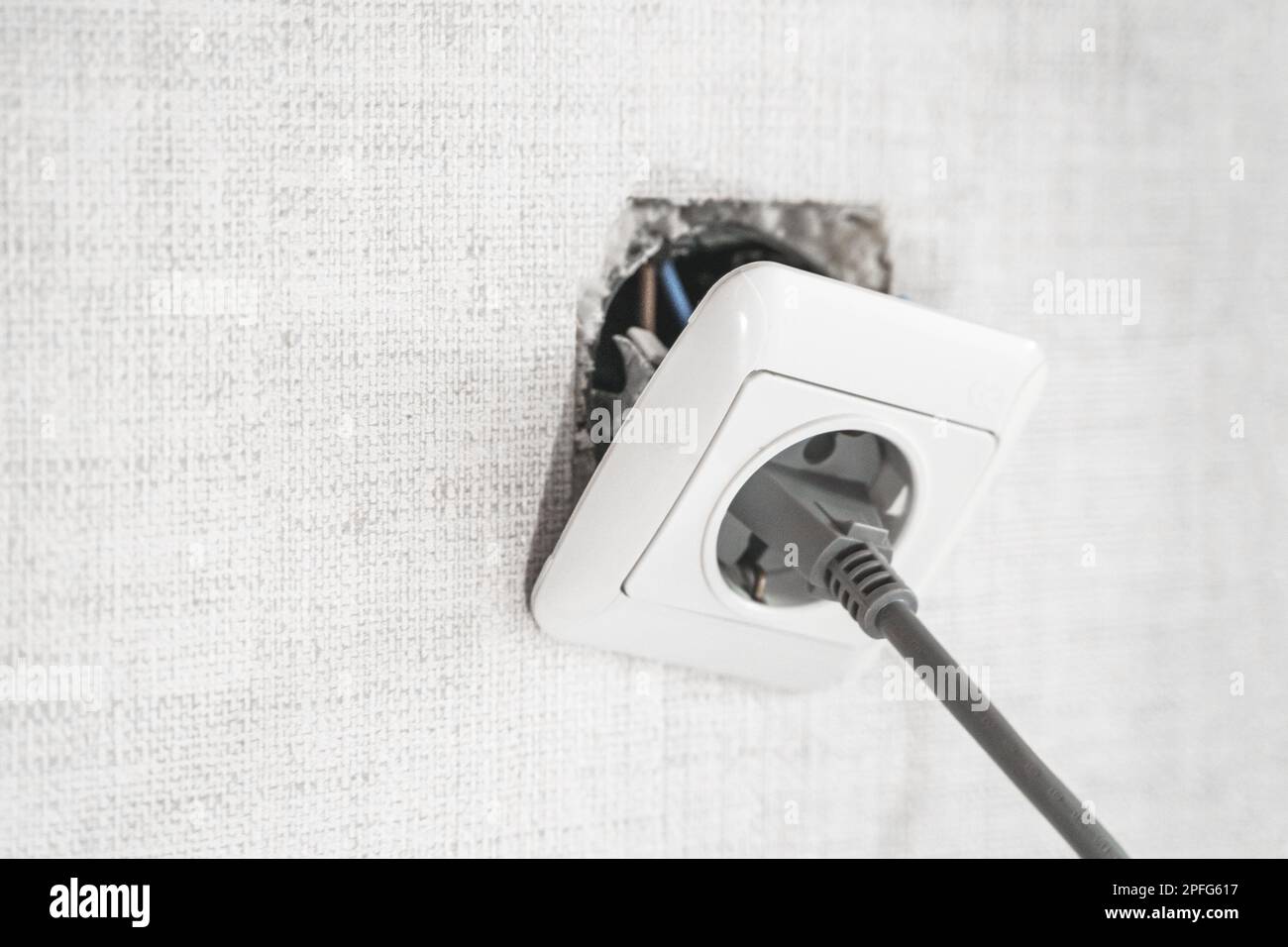 Dangerous bad,broken socket,plug in bathroom,falling out of wall. Outlet installation in old apartment. Poor electrical wire,repair.Terrible do-it-you Stock Photo