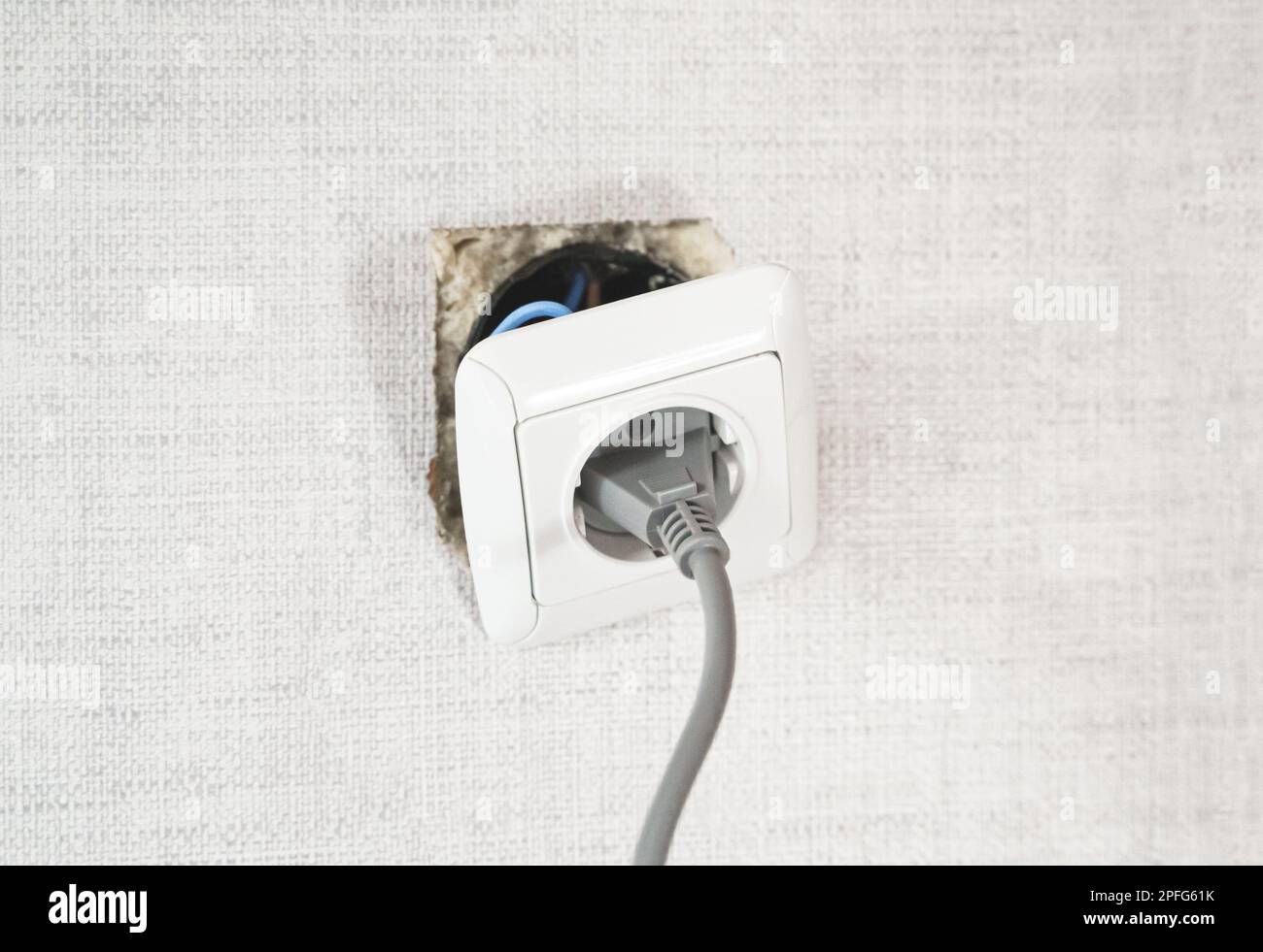 Dangerous bad,broken socket,plug in bathroom,falling out of wall. Outlet installation in old apartment. Poor electrical wire,repair.Terrible do-it-you Stock Photo