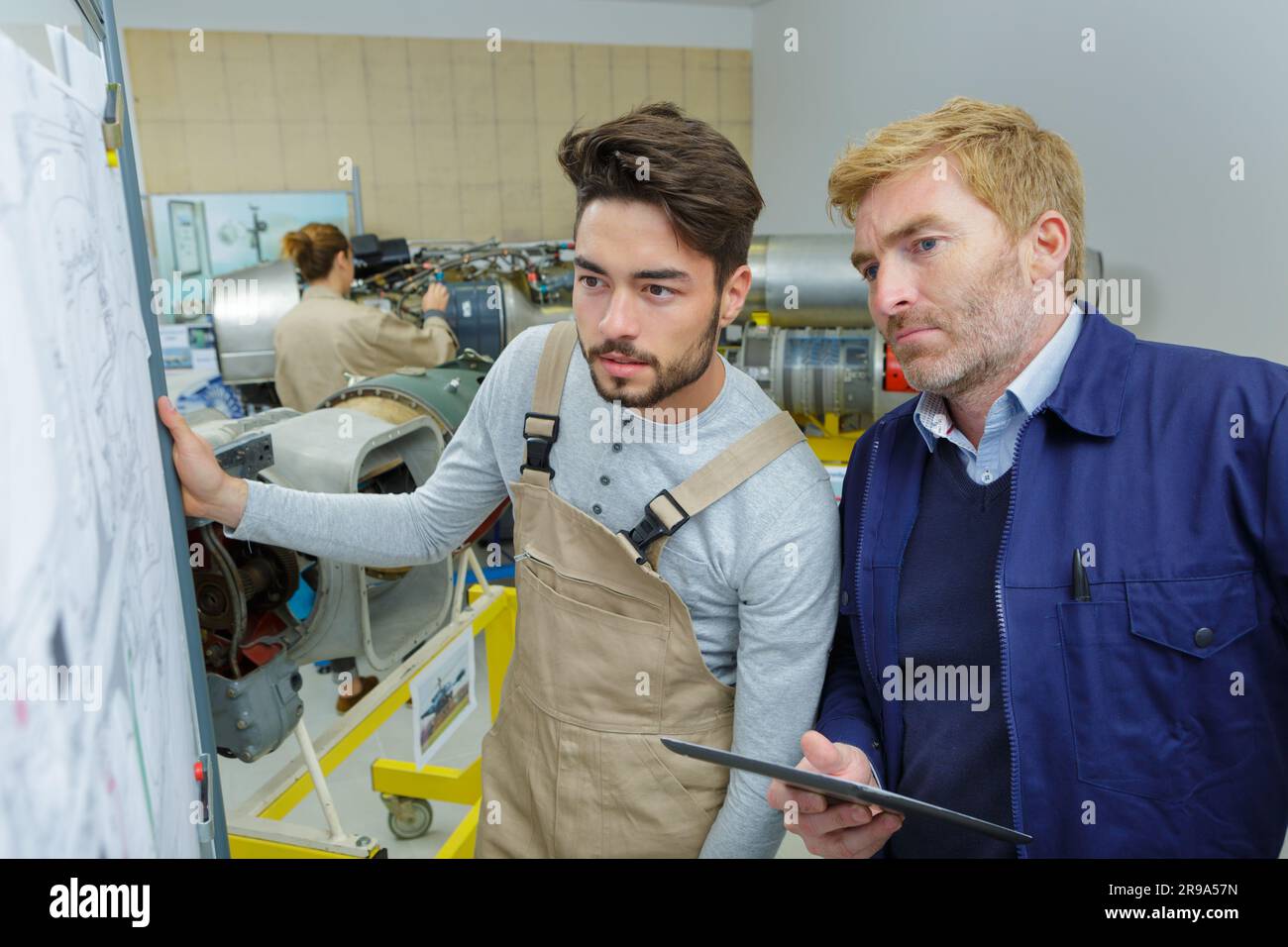 two young creative engineers working on drawing board Stock Photo