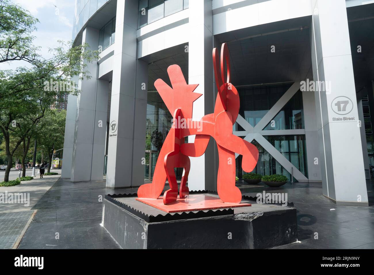 A red steel sculpture by Keith Haring is located at 17 State Street across the street from the Battery. It is entitled 'Figure Balancing on Dog.' Stock Photo