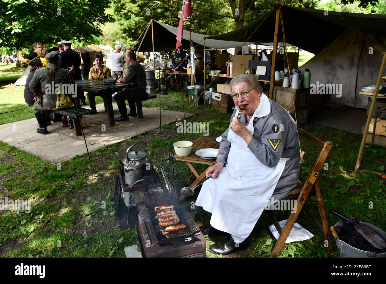 World War Two weekend in the Ironbridge Gorge. Reenactors dressed as Nazi German forces army cook with female eating Bratwurst. Stock Photo