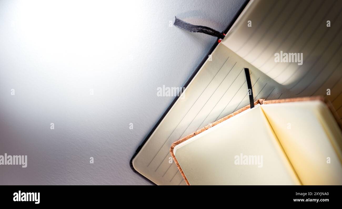 Two open notebooks. Lined and clean pages. Cork binding. White background copy space. Stock Photo