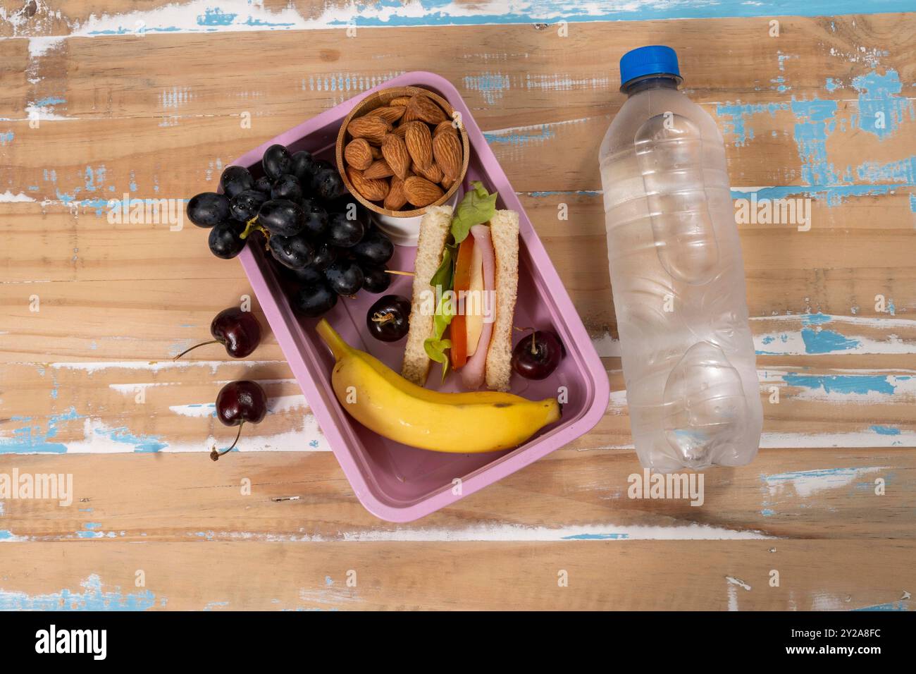 School lunch presentation. Top view showing eco-friendly lunch box filled with nutritious foods, protein, fruit and grains Stock Photo