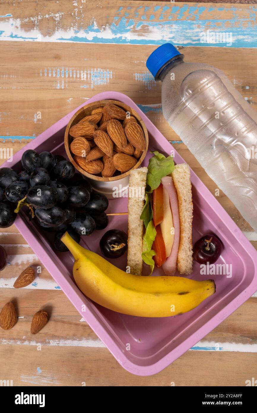 School lunch presentation. Top view showing eco-friendly lunch box filled with nutritious foods, protein, fruit and grains Stock Photo