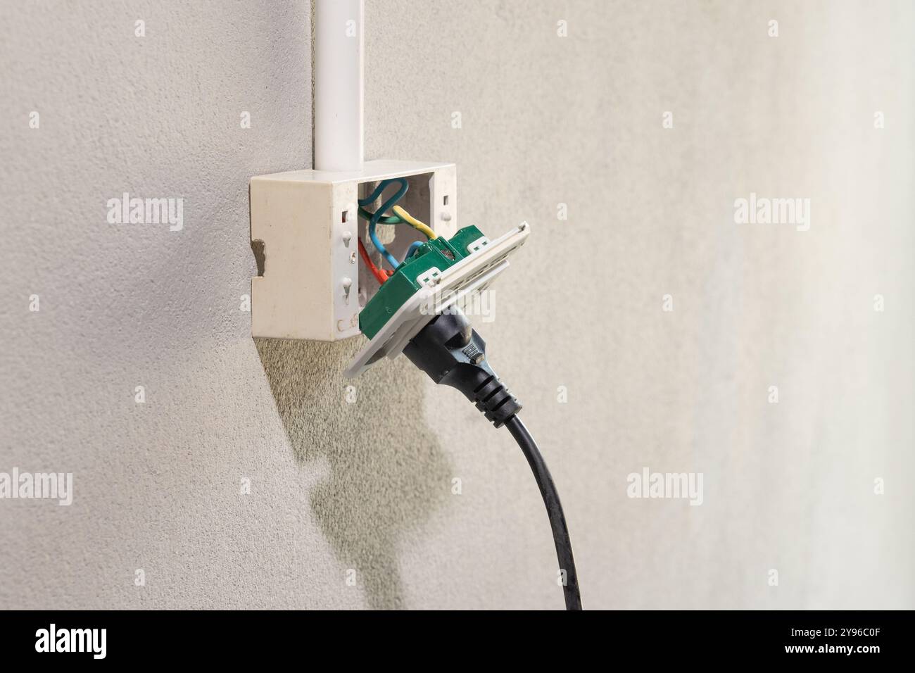 Dangerous broken electrical socket falling out of wall. Stock Photo