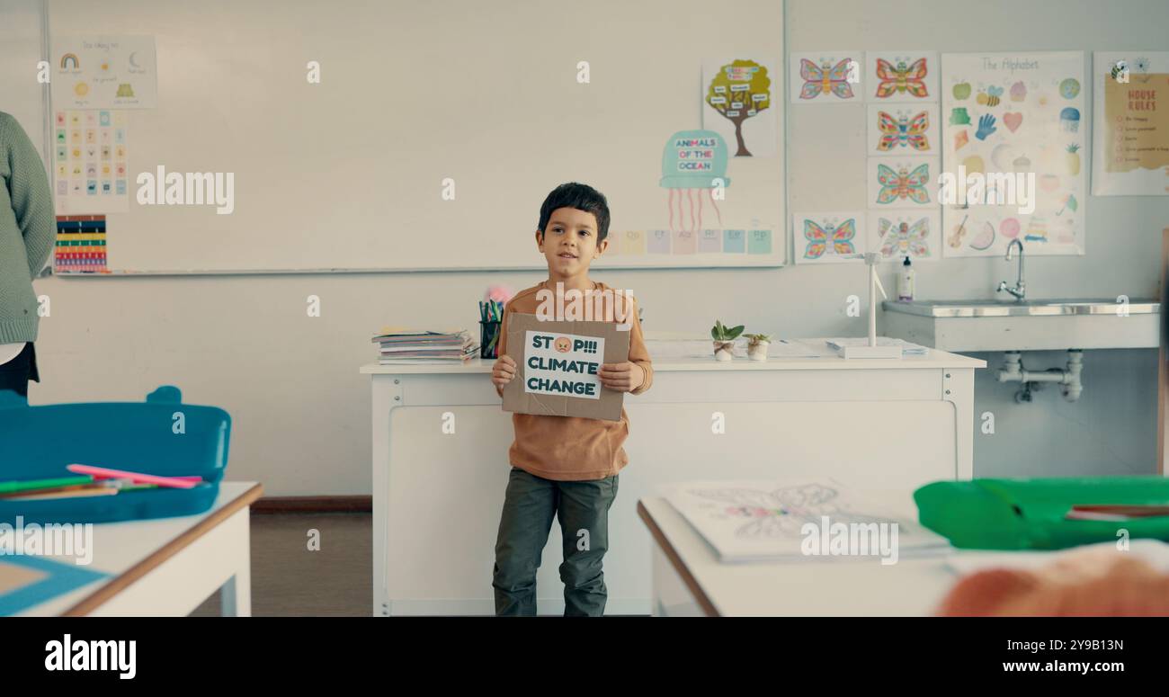 Student, boy and presentation with poster in classroom for eco friendly project, sustainability lesson and climate change. School, child and oral Stock Photo