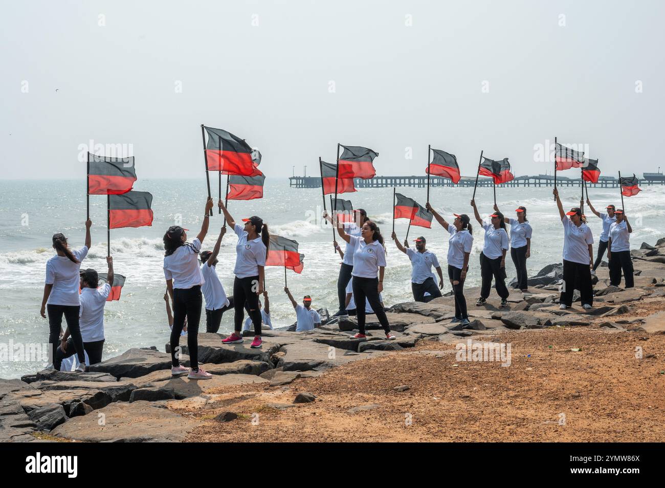 A group of young people, most of them women, hold a flag with the colors of the DMK party Stock Photo